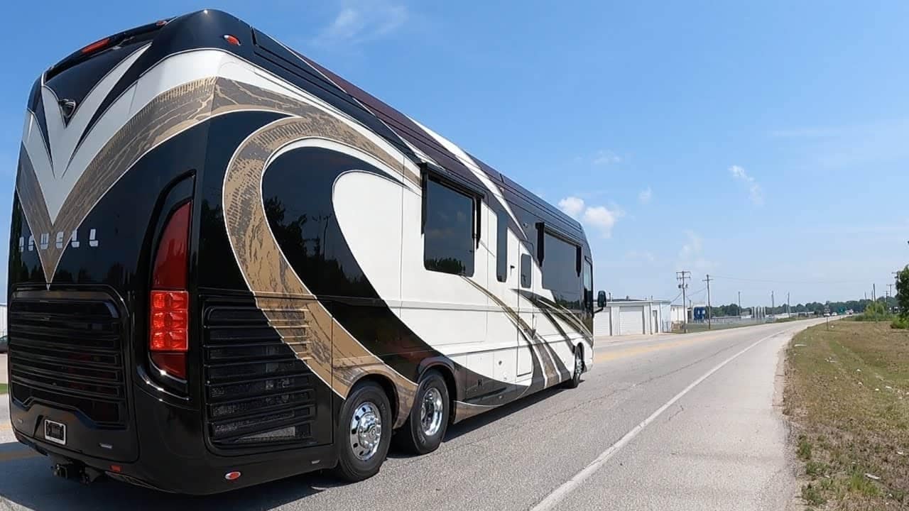 A black and white Newell Coach 1730 rv is parked on the side of the road with the nicest interior.