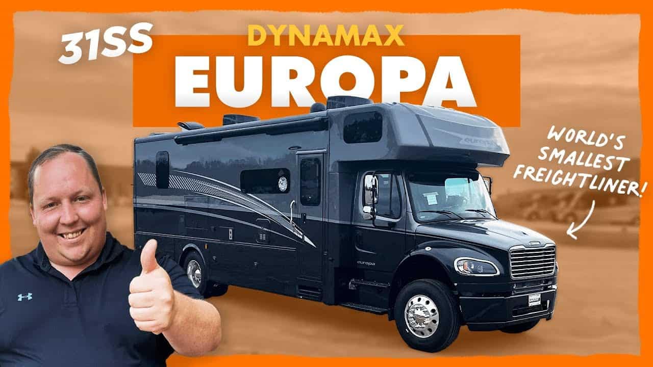A man is giving a thumbs up in front of the World's smallest rv with the words dynamax europa.