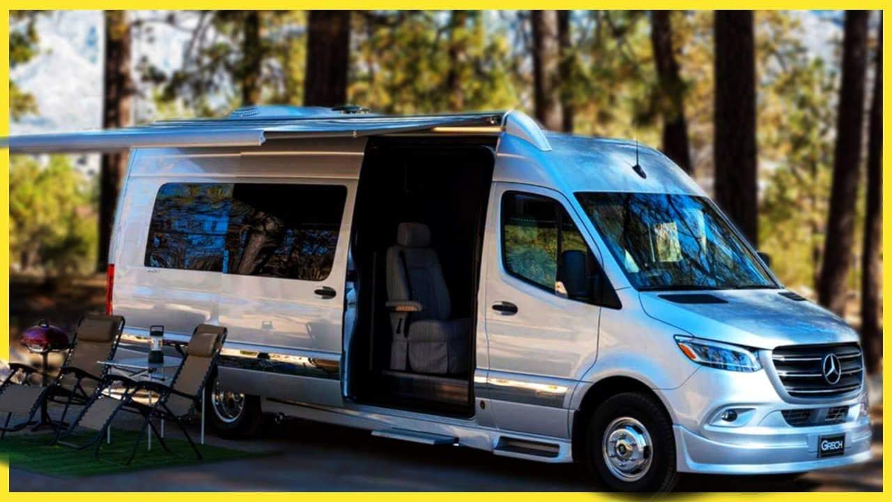 A silver Grech Class B camper van parked in the woods.