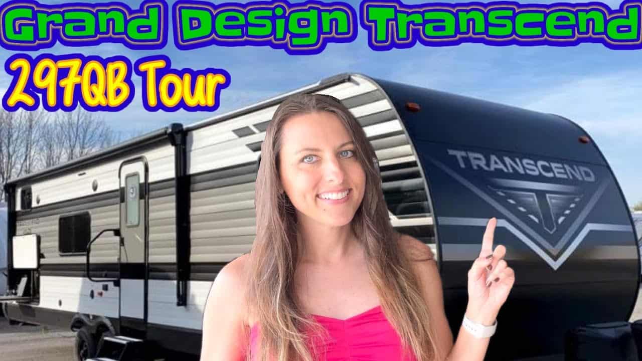 A woman is posing in front of a 2022 Grand Design Transcend Xplor 297QB RV during an RV Tour.