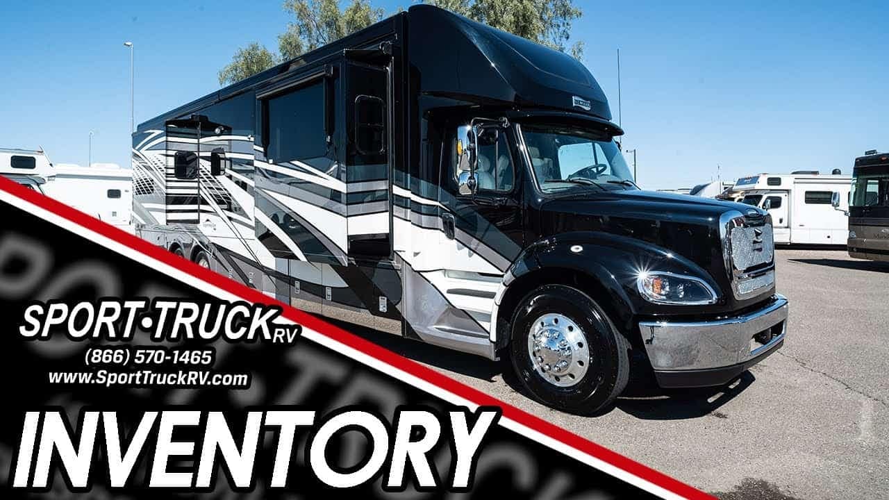 A black and white RV from the 2022 Newmar Supreme Aire 4590 series is parked in a lot.