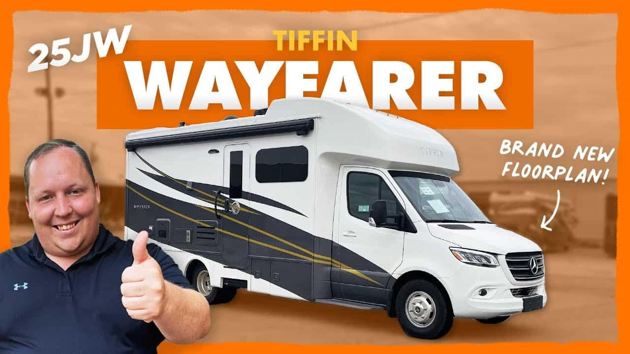 A man is giving a thumbs up in front of a 2022 Tiffin Wayfarer RV.