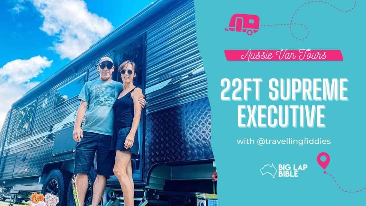 A couple standing in front of a Supreme Executive Caravan.