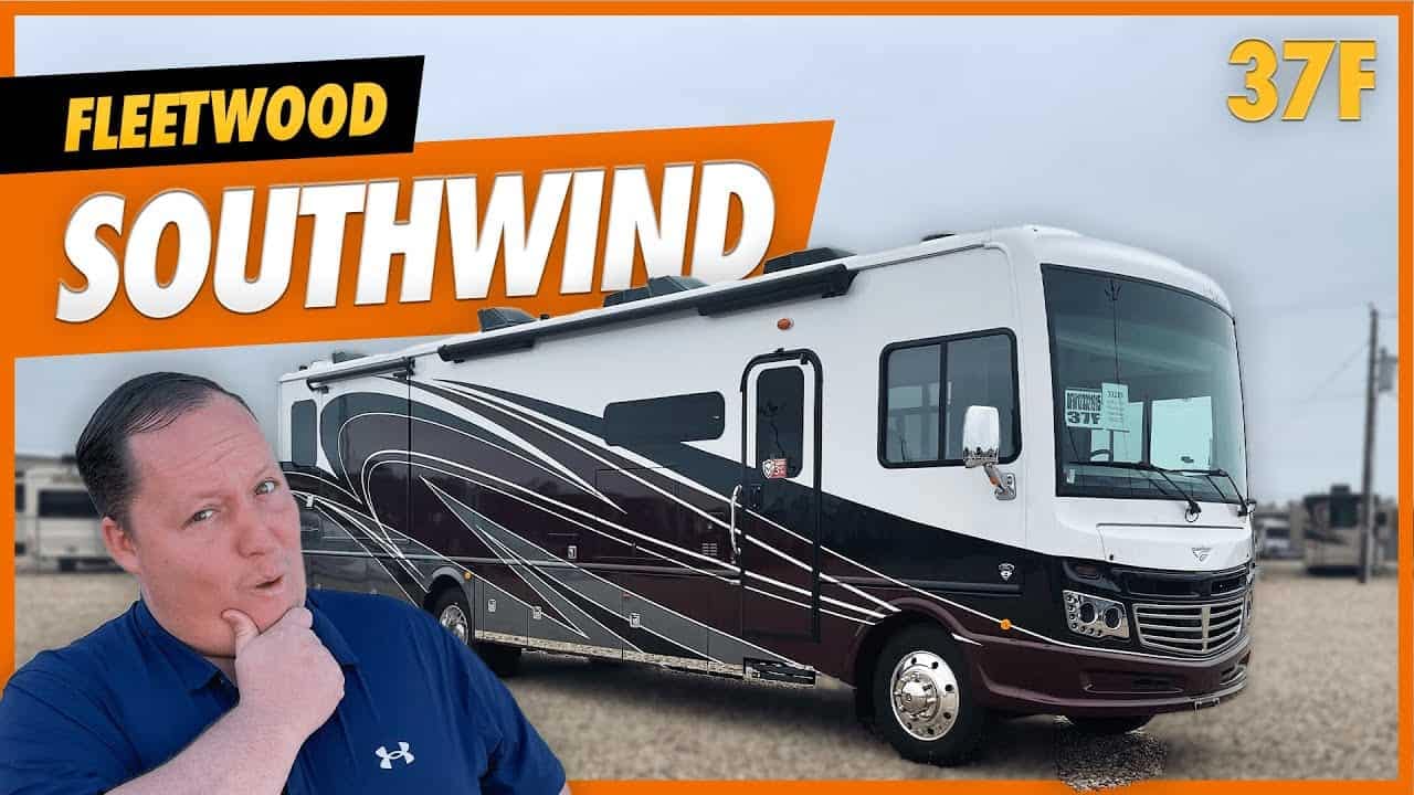 A man is proudly standing in front of a Fleetwood Southwind RV.