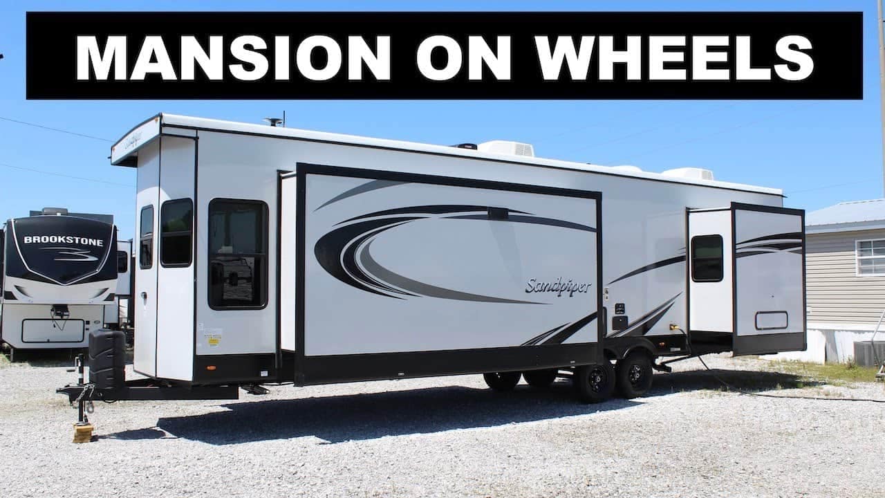 A black and white Sandpiper Destination park model with the words mansion on wheels.