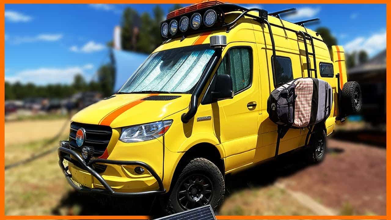 A customized yellow van, equipped with a solar panel on the roof, belonging to the Nomad Vanz brand.