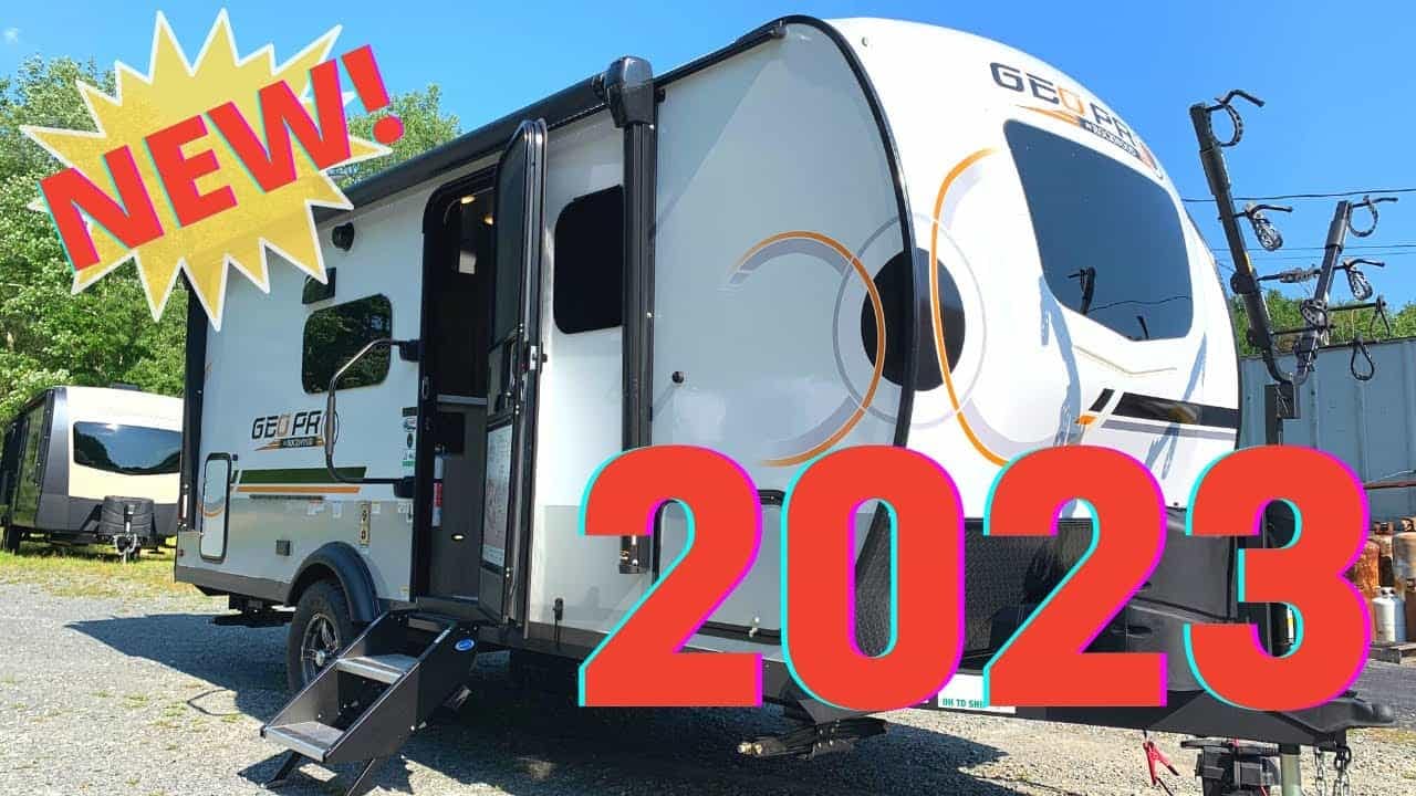 A new Forest River RV, specifically a Rockwood Geo Pro model, is parked in front of a travel trailer.