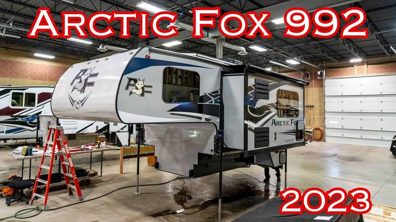 A compact 2023 Arctic Fox 992 truck camper transformed into a comfortable home inside a garage.