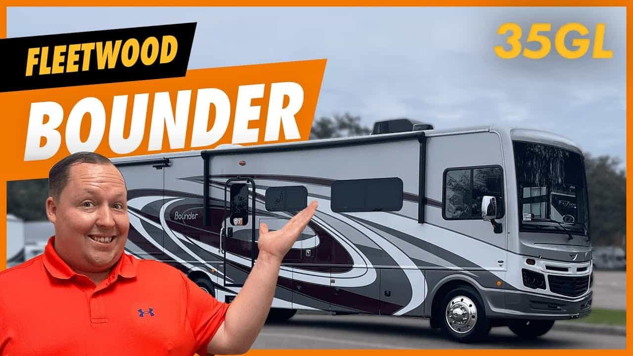 A man is posing in front of a 2023 Fleetwood Bounder motorhome.