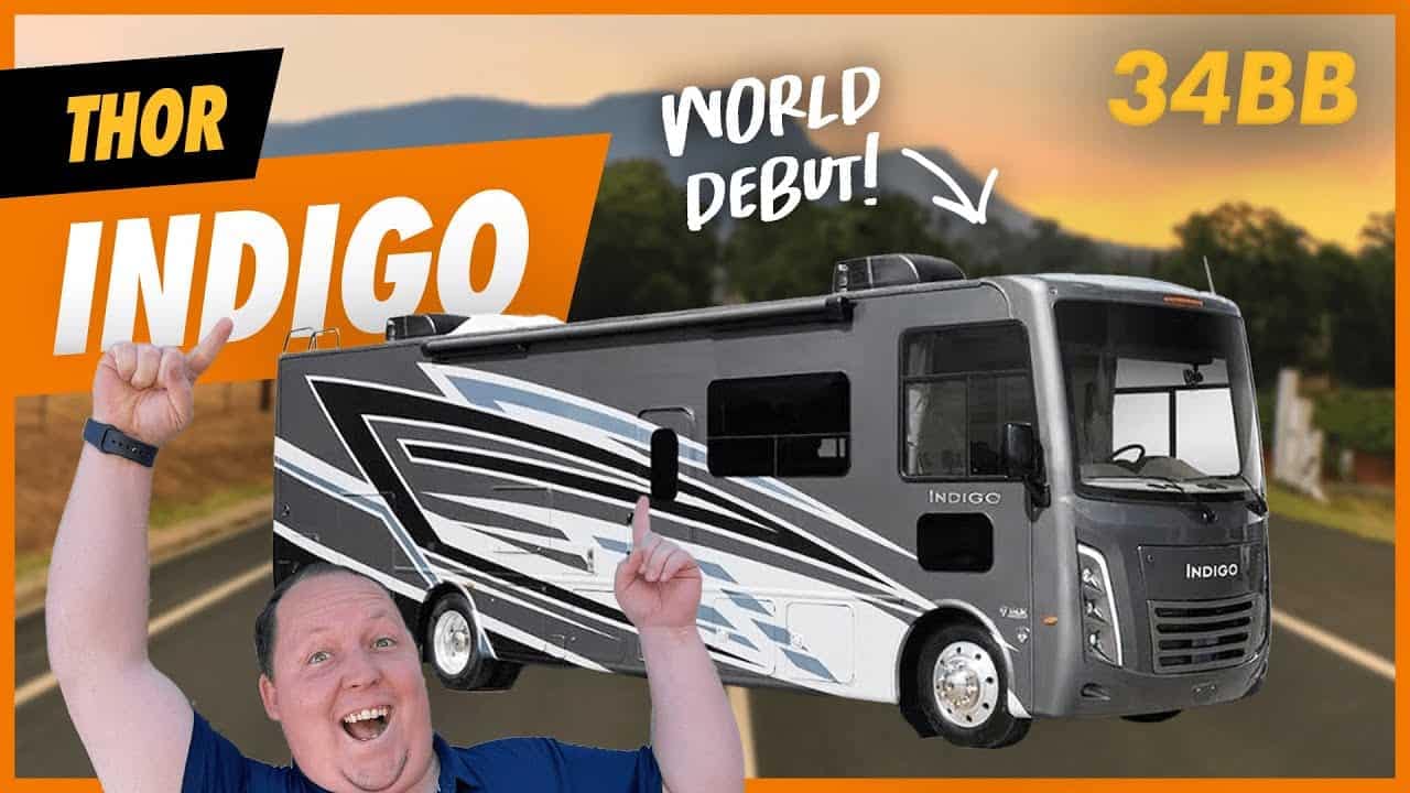A man is standing next to a Thor Indigo 34BB RV.