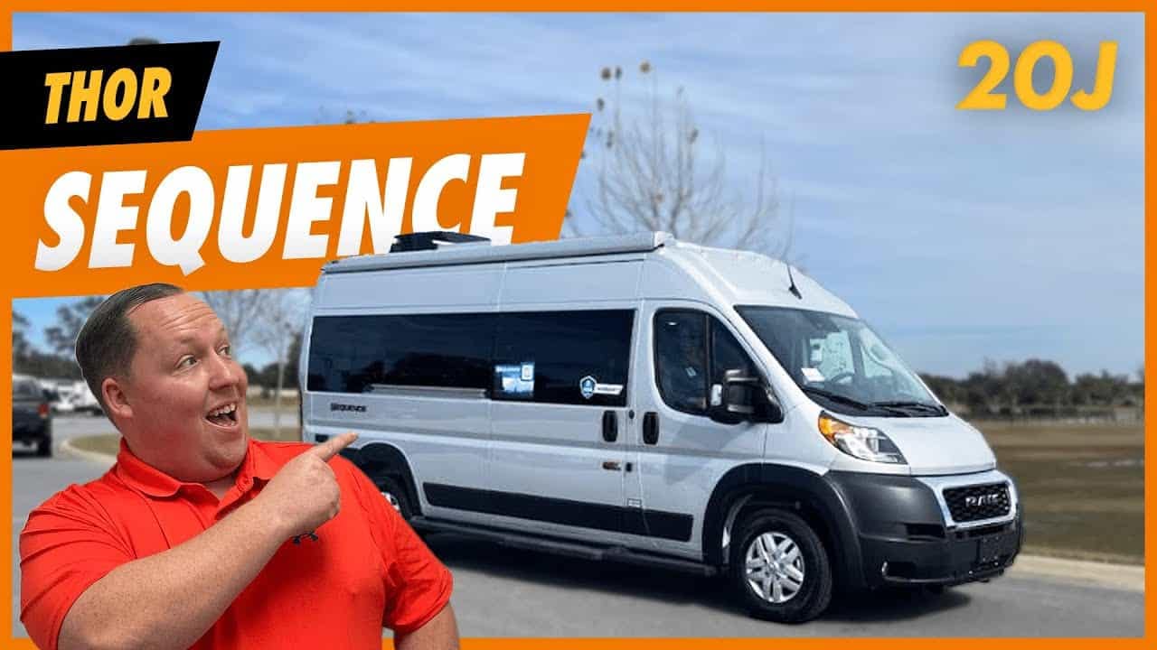 A man is standing in front of a van with the words Thor Motor Coach.