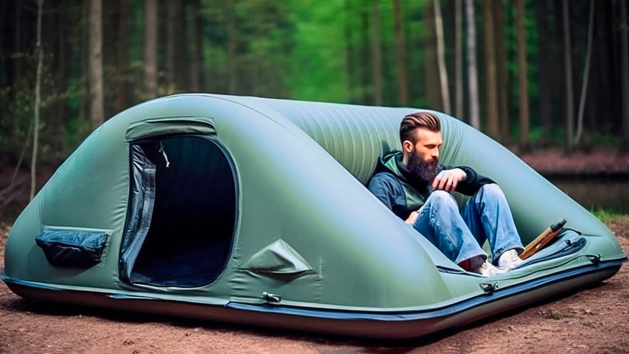 An innovative man sitting in an inflatable tent surrounded by nature while enjoying camping adventures.