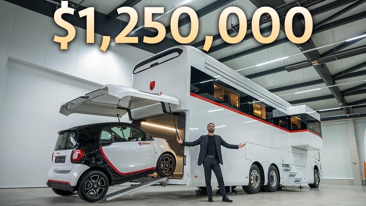 A man standing next to a dembell motorhome in a garage, demystifying luxury travel.