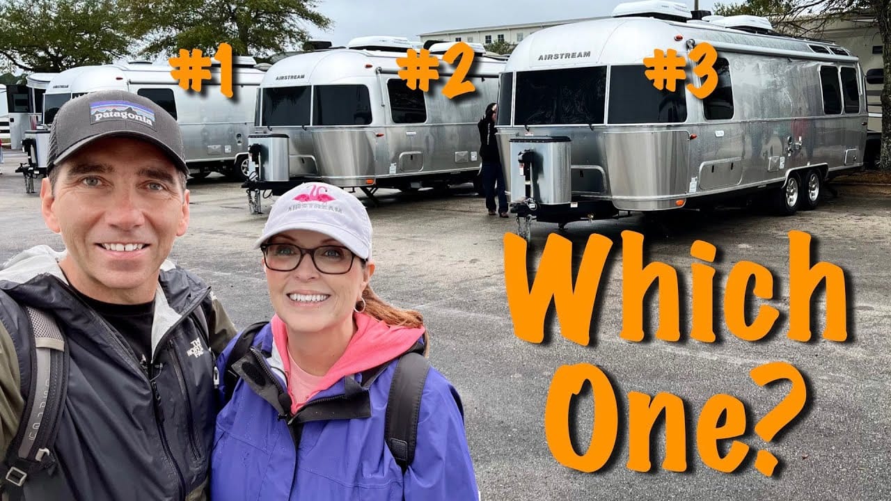 Two people standing in front of an Airstream RV, contemplating their choices for the Buyer's Guide.
