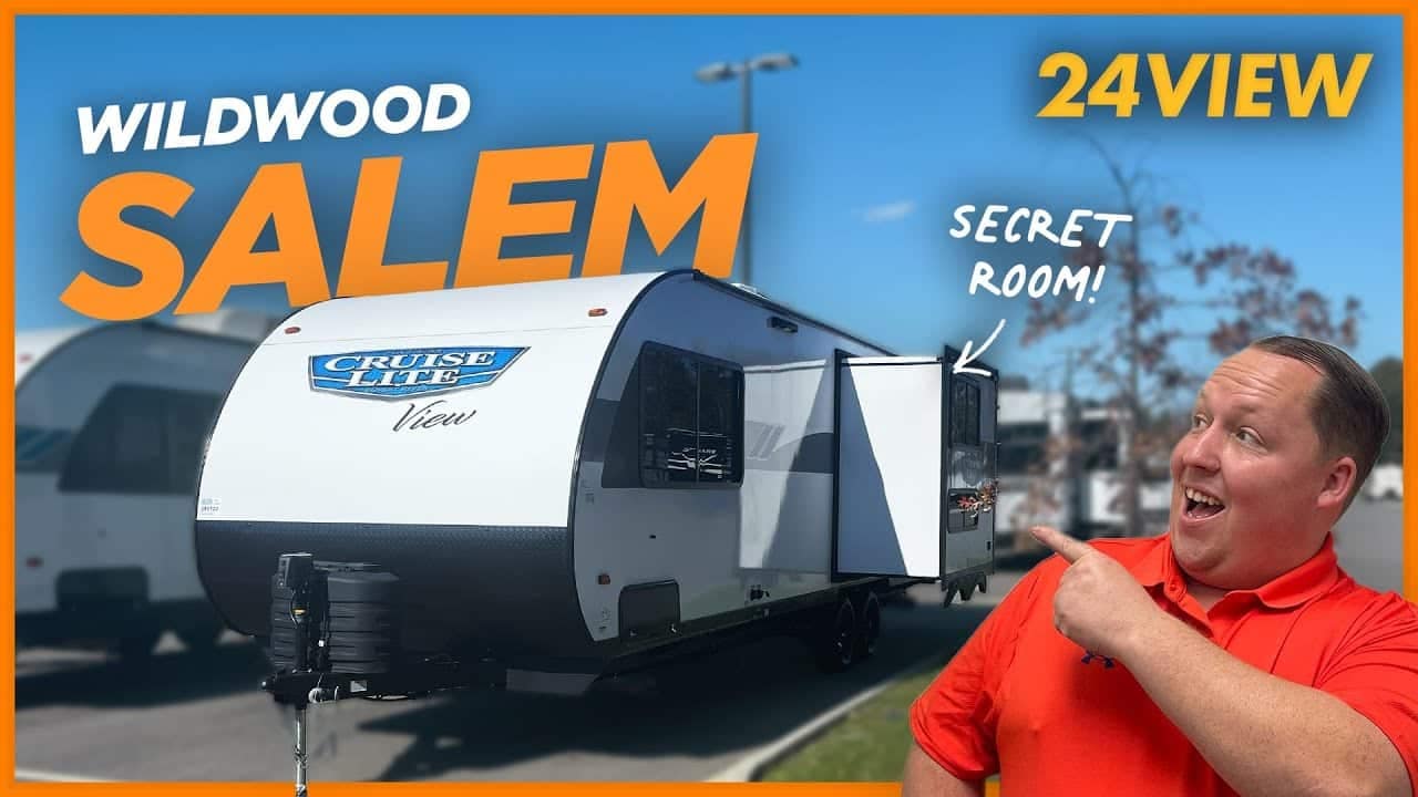 A man is standing in front of an innovative design RV with the words Wildwood Salem.
