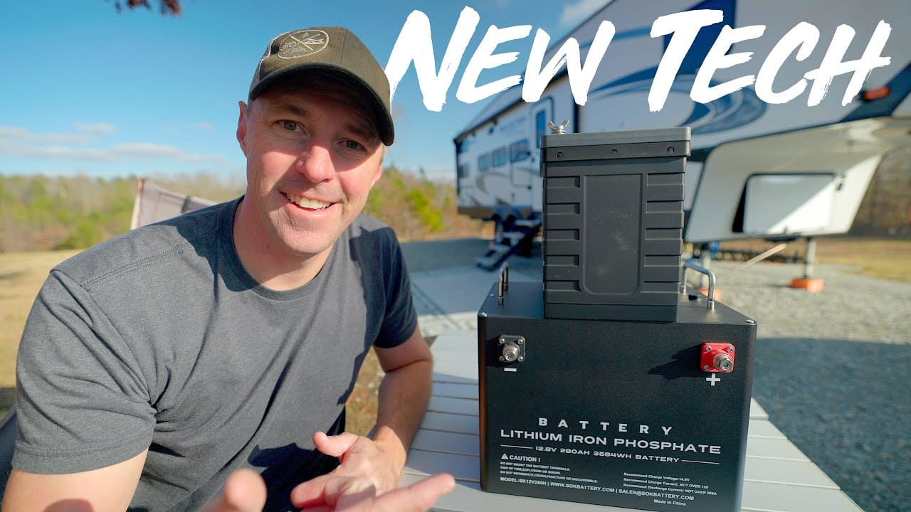 A man is standing next to a new RV battery.