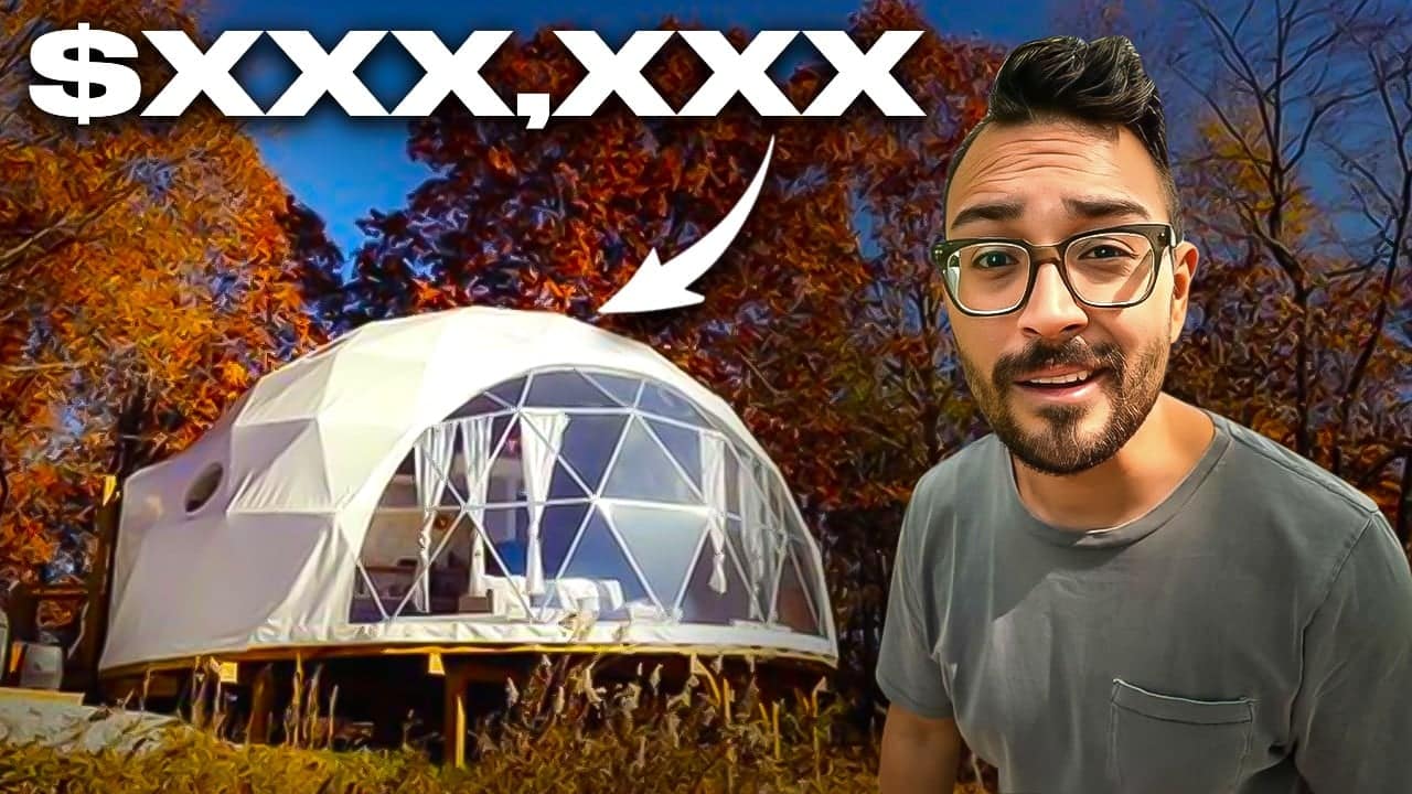 A man in glasses is standing in front of a geodome building.