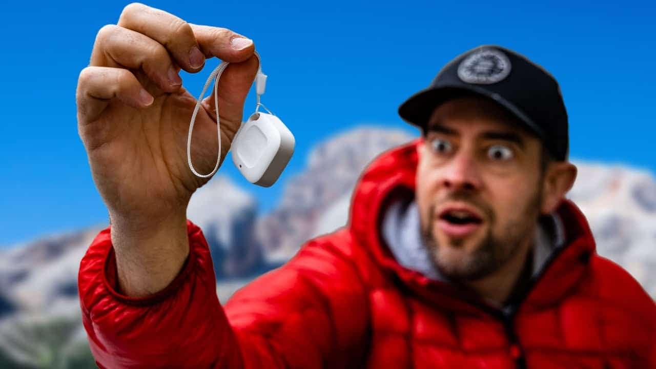 A modern adventurer holding up an innovative camping gadget in front of mountains.