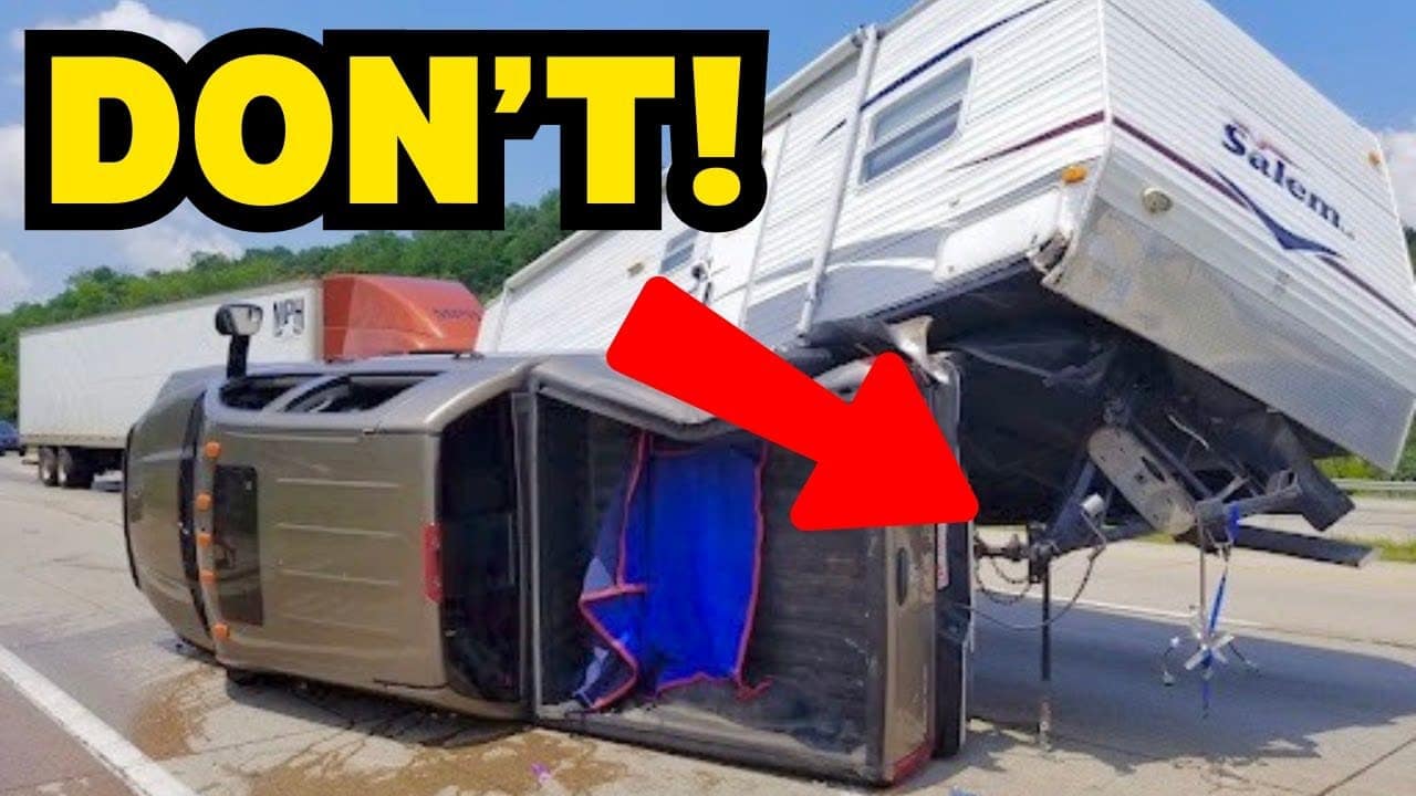 A travel trailer is upside down on the side of the road.