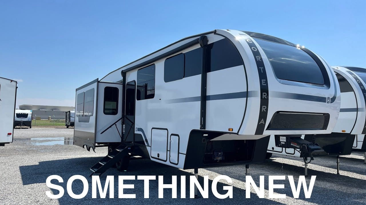 Modern recreational auto draft parked on a concrete lot under a clear sky with the text "something new" displayed.