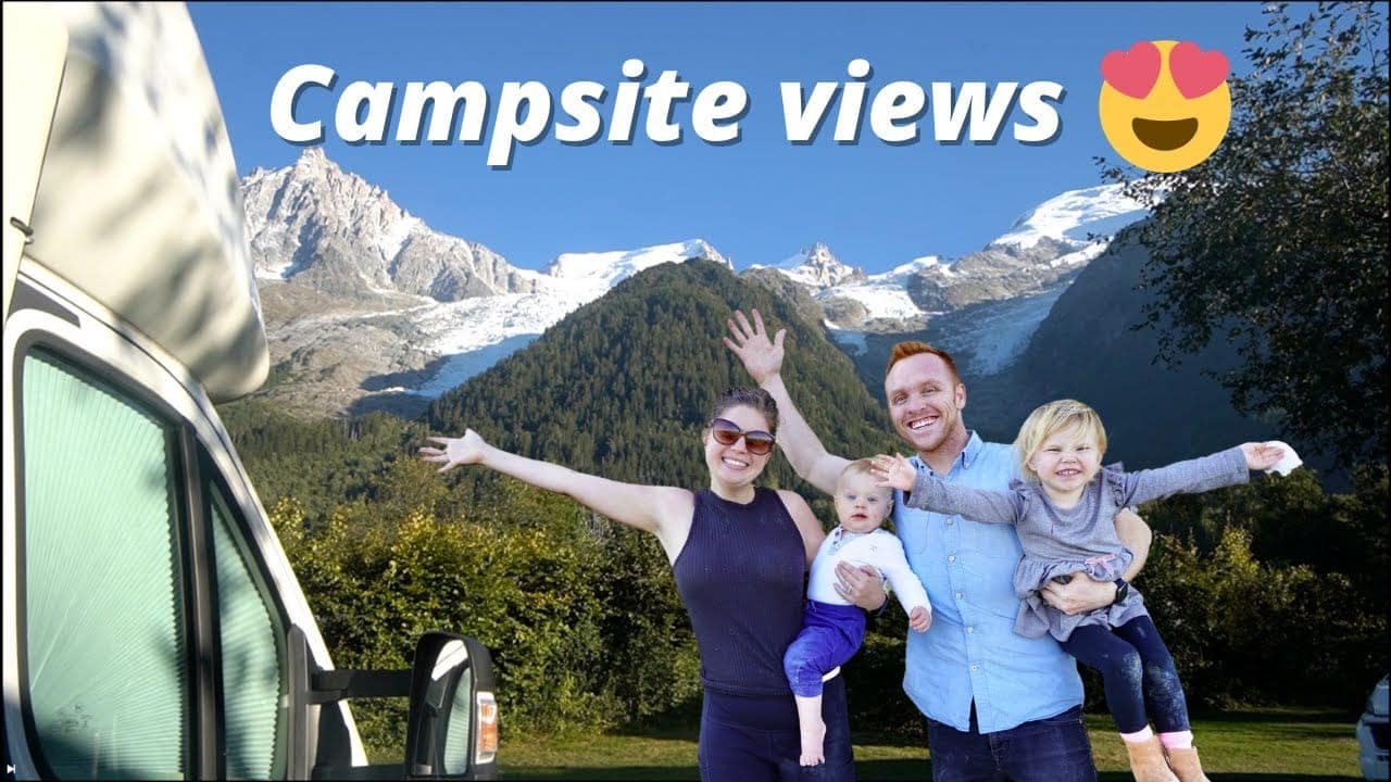 A family smiling and waving in front of a camper van with mountain scenery in the background, labeled "Auto Draft" with a heart-eyed emoji.