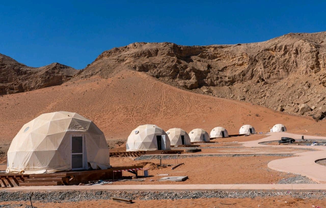 A group of dome tents in the desert at an Out of this World glamping resort in Sharjah.