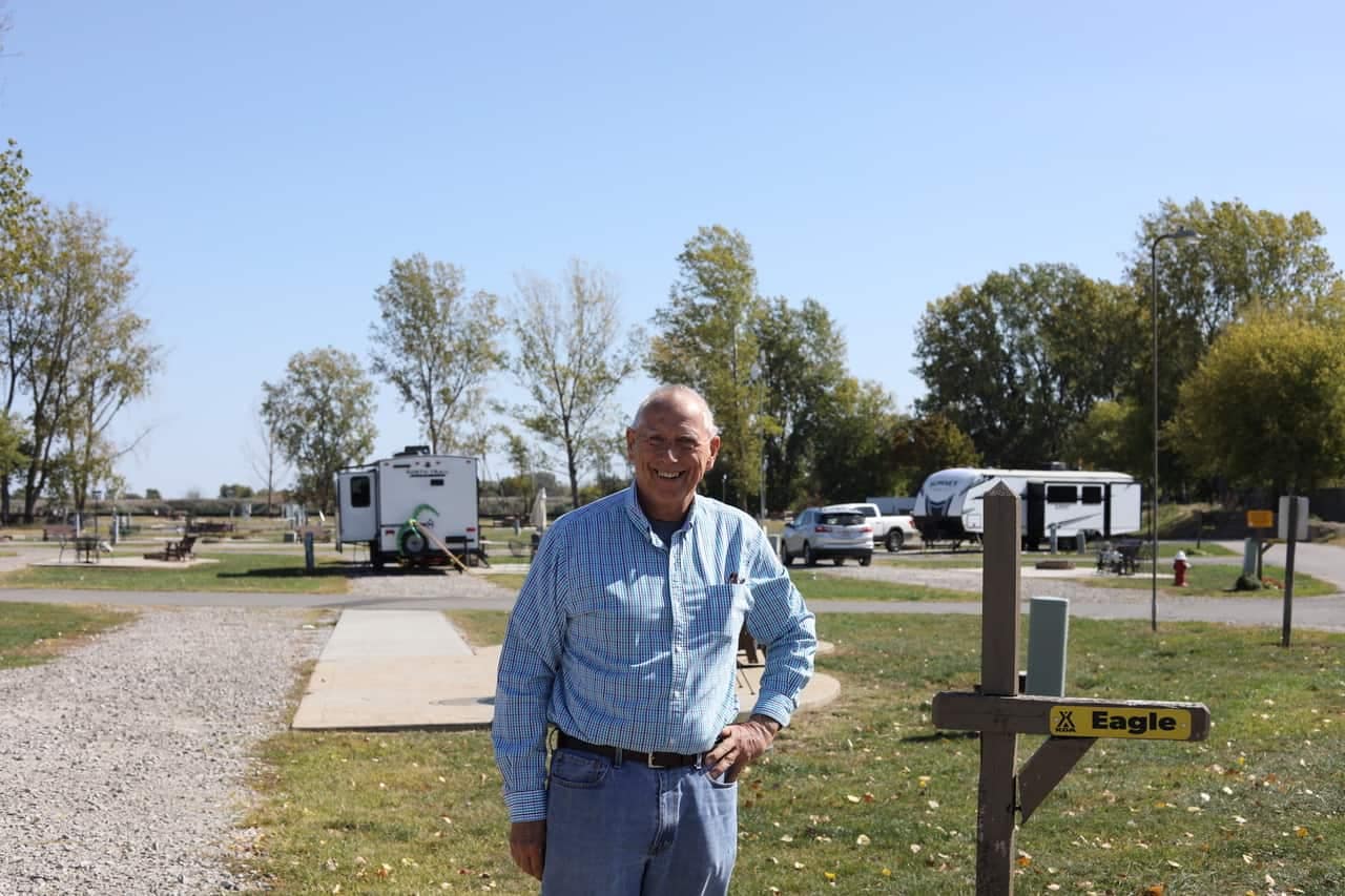 A man standing in front of a sponsored RV park.