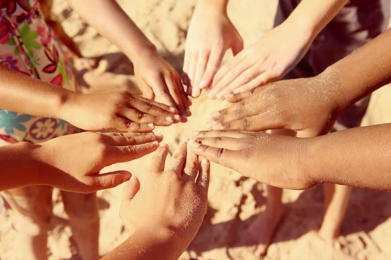 Children's hands forming a circle during recreational activities.