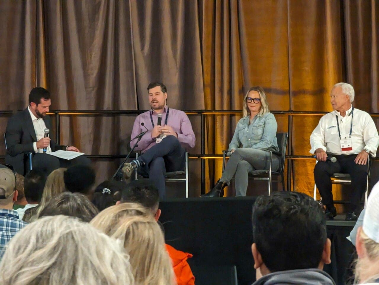 A group of businesses sitting in chairs at a conference discussing potential fund opportunities for Glamping ventures.