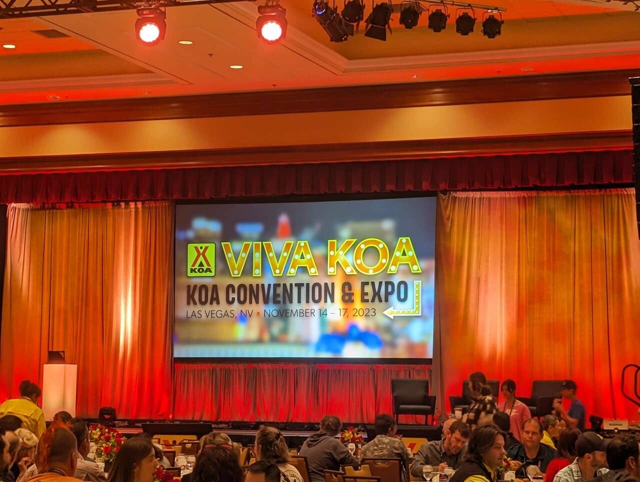 A group of people sitting at a table at a convention during the General Session.