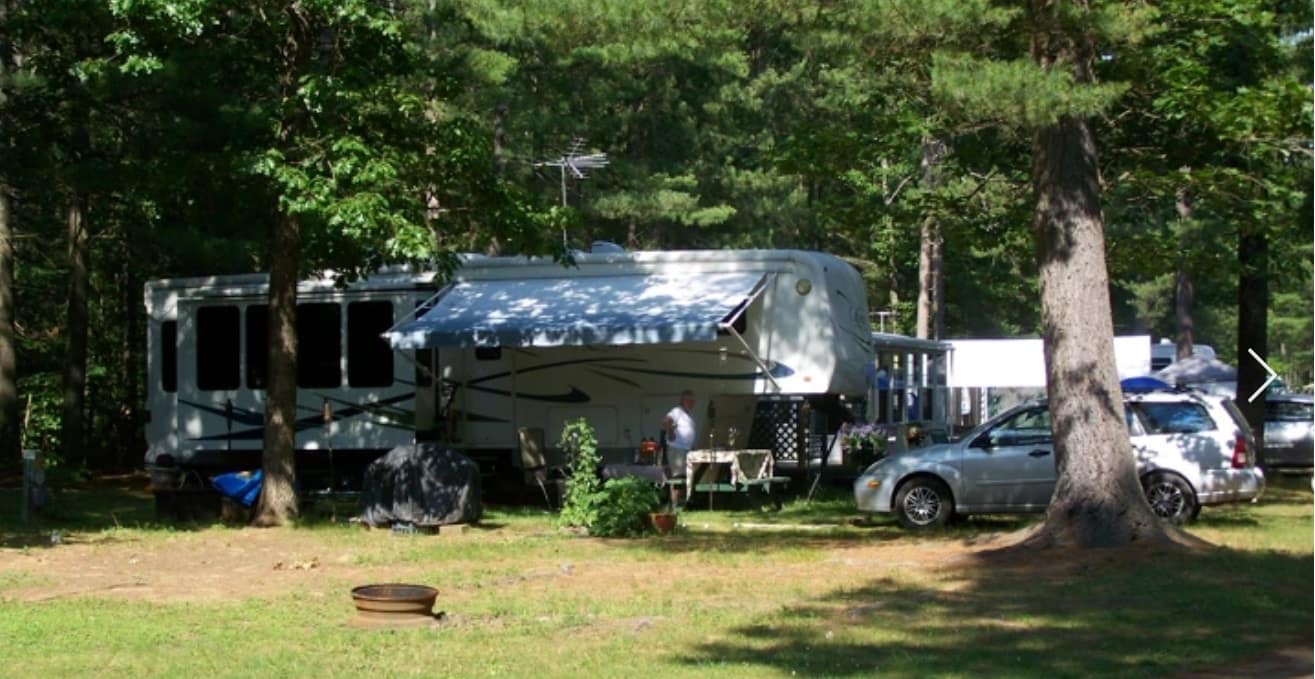 An RV parked in the wooded area of Iroquois Campground near Lake Champlain.