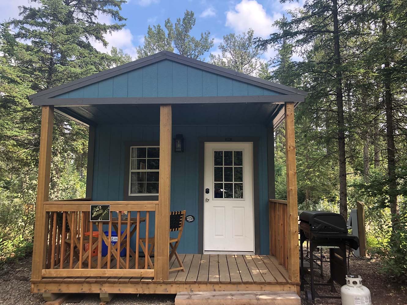 A small cabin in the woods with a grill, perfect for special celebrations.