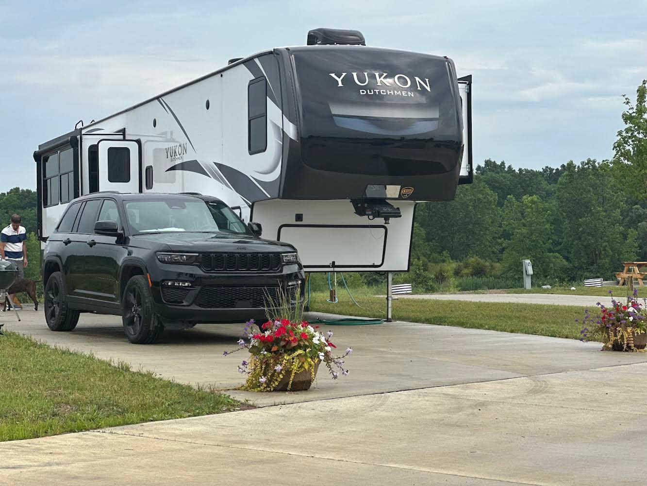 A summertime scene at Hidden Lakes with a jeep parked next to an RV in the resort.