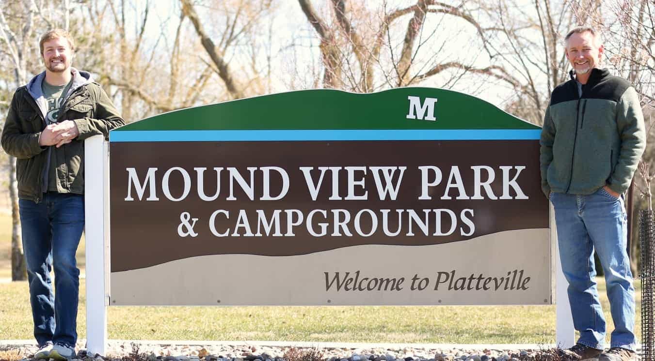 Two men standing in front of a newly expanded sign that says Mount View Park and Campgrounds.