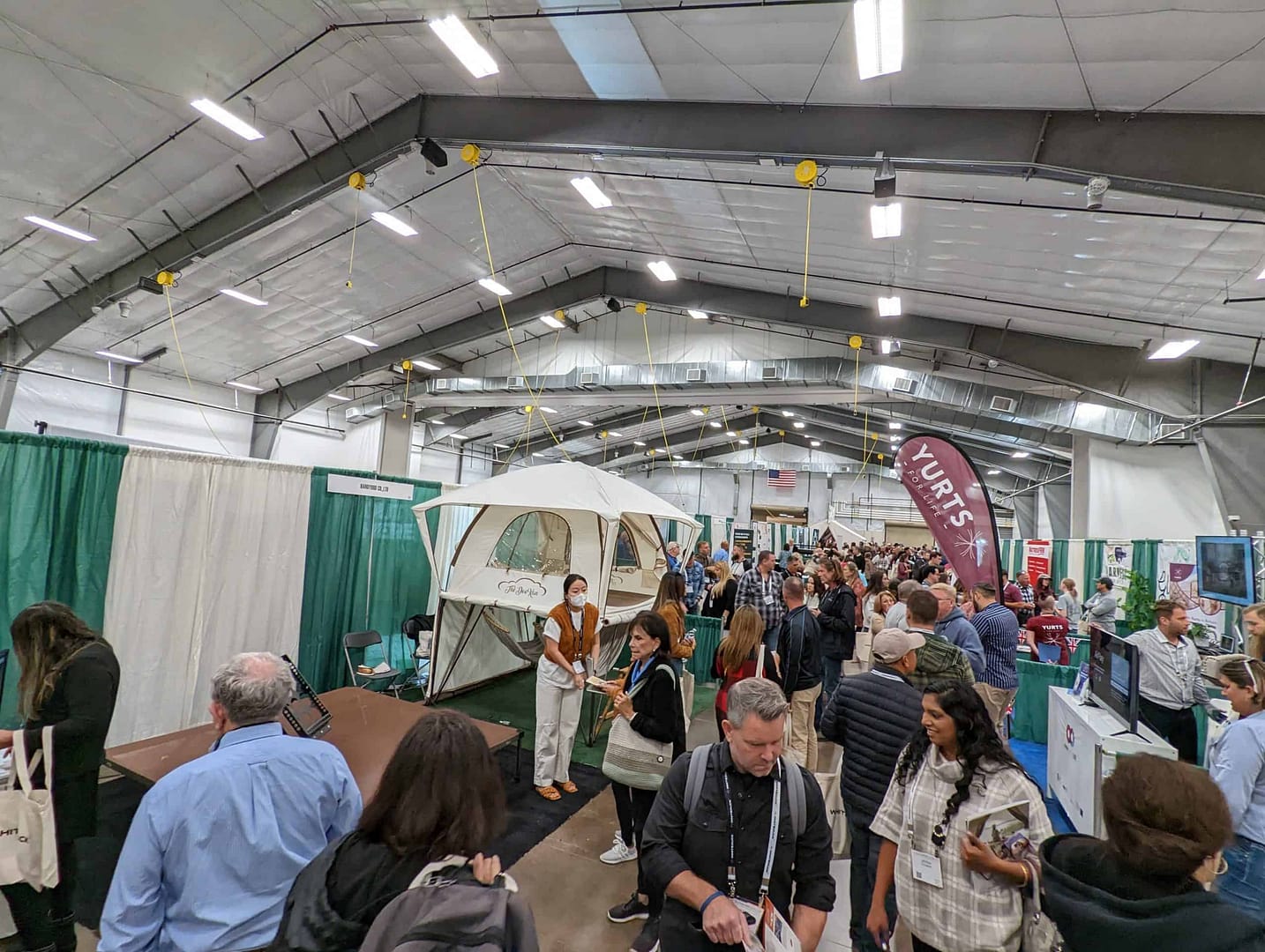 A crowd of people at a trade show, attending Whitney Scott's Keynote Presentation at the Glamping Show USA.