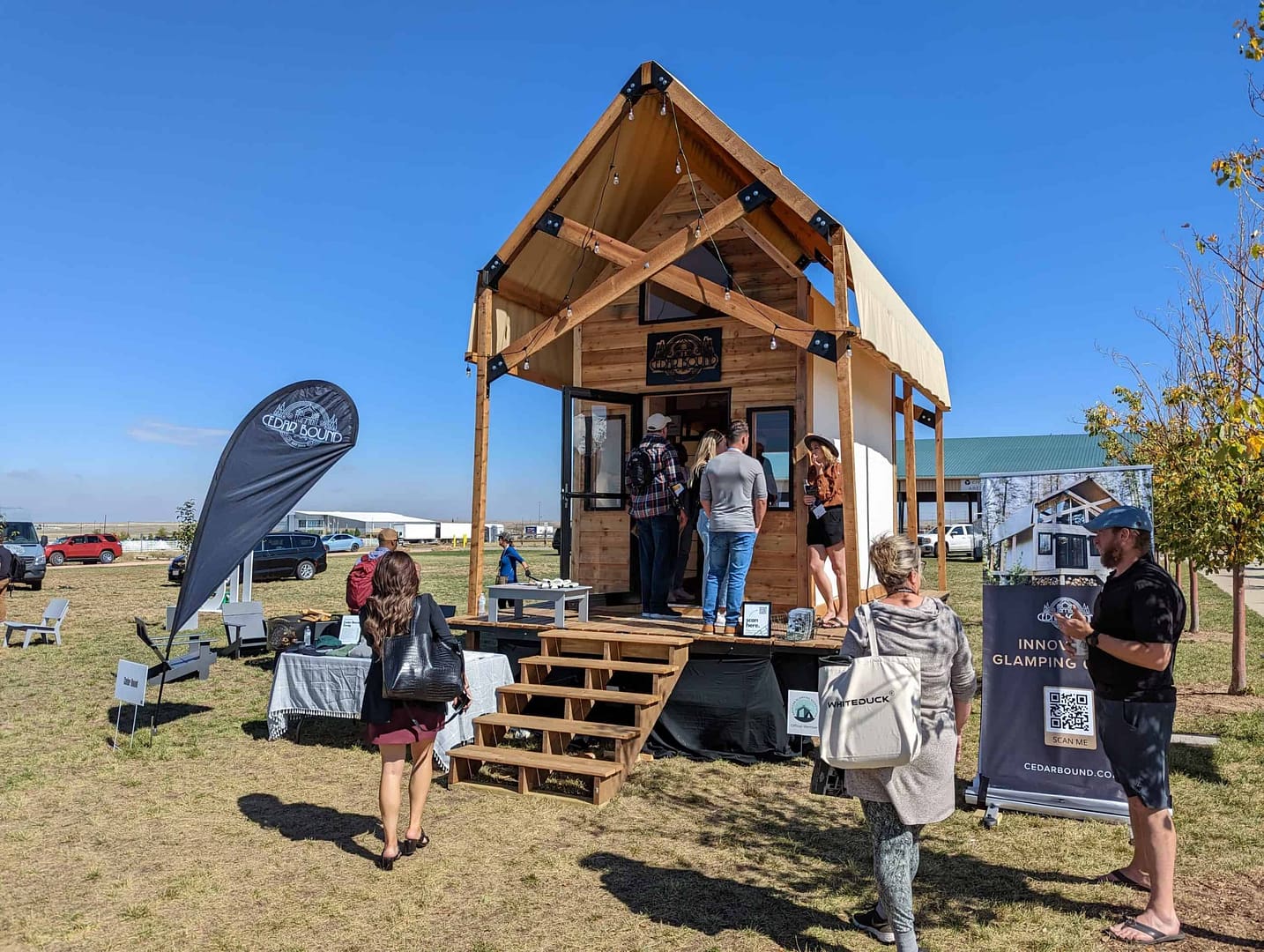 Attendance at the Glamping Show USA 2022 event surpassed last year's as a group of people gathered outside of a tiny house.