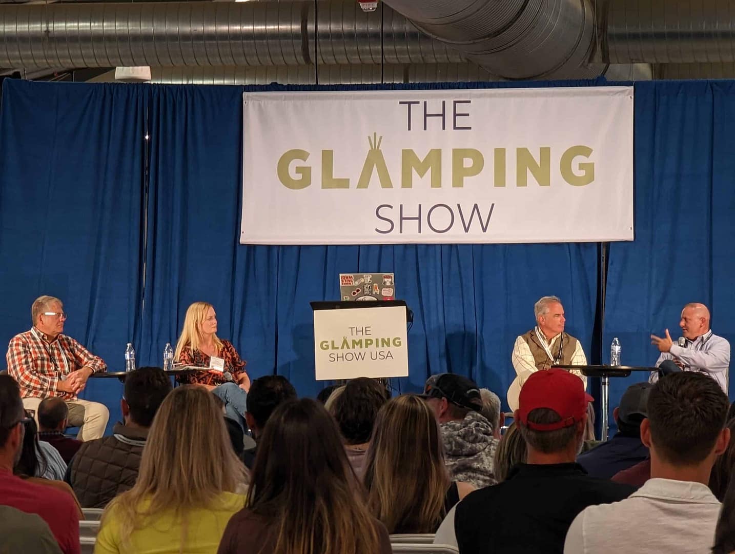 Attendance Up at the Glamping Show USA with People gathered in front of a banner.