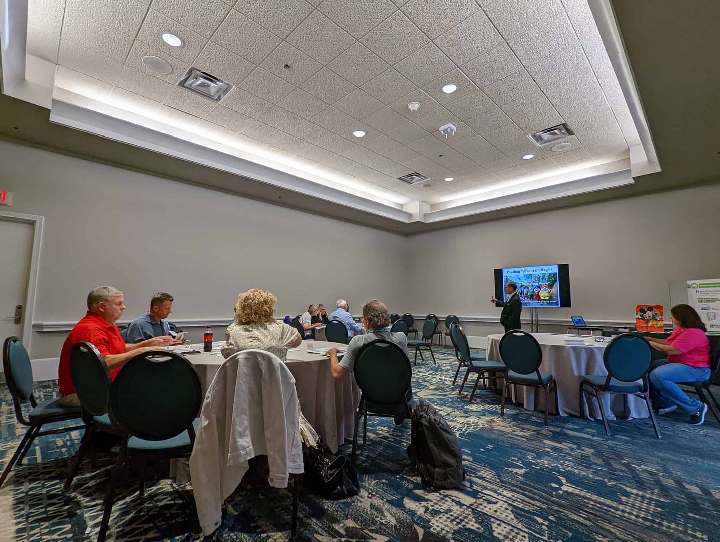 A group of culture enthusiasts sitting around tables in a conference room.