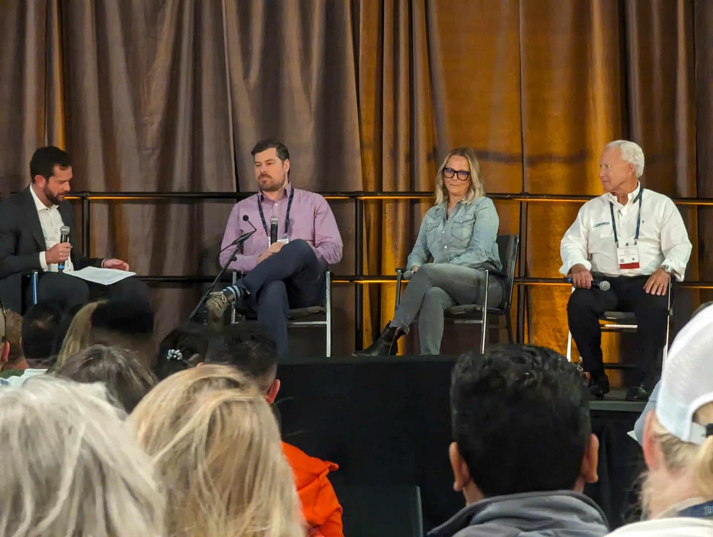 A group of people sitting on a stage during the Glamping Show USA in 2023.