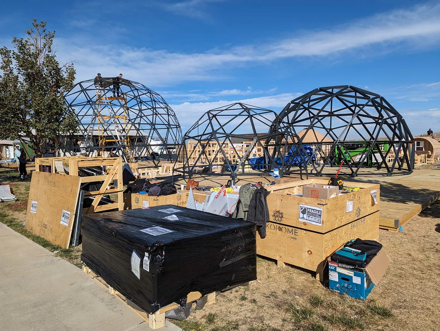 Preparations are underway for a glamping show at a house, featuring a group of metal domes.