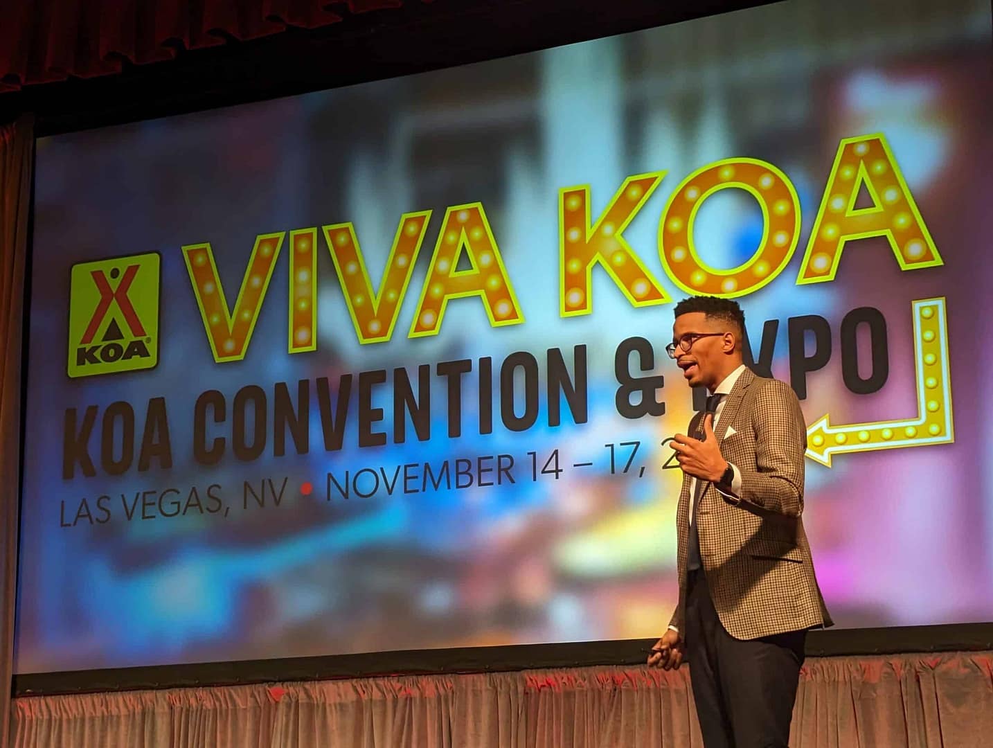 An expert speaking on stage at the Viva Koa convention and expo, discussing growth tools.