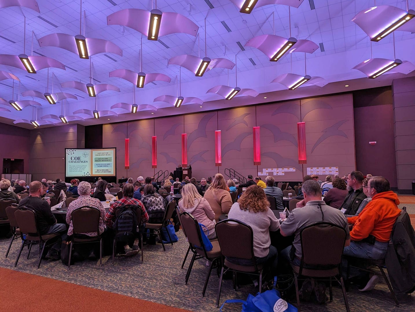 A large group of people sitting at tables in a conference room, engaged in networking during the Campground Owners Expo.
