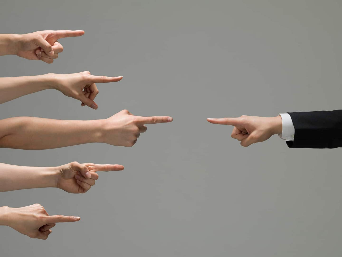 A group of business people pointing at each other during a meeting to discuss the proposed limits.