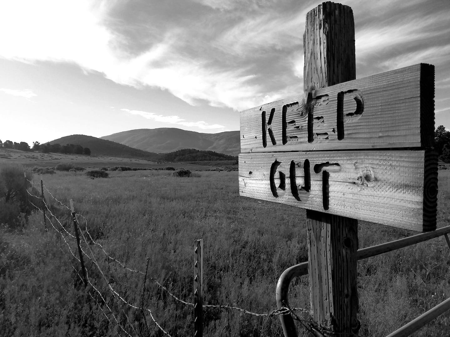 A black and white photo of a wooden sign that says keep out, opposing residents in Washington.