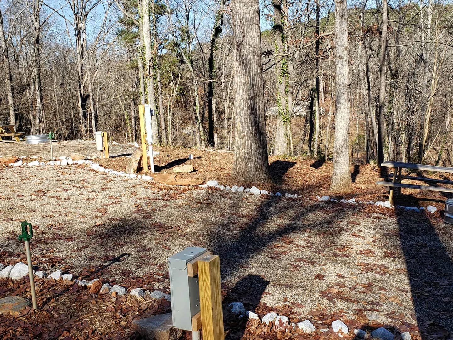 A new RV park in Tennessee that offers a serene wooded area complete with a picnic table and benches.