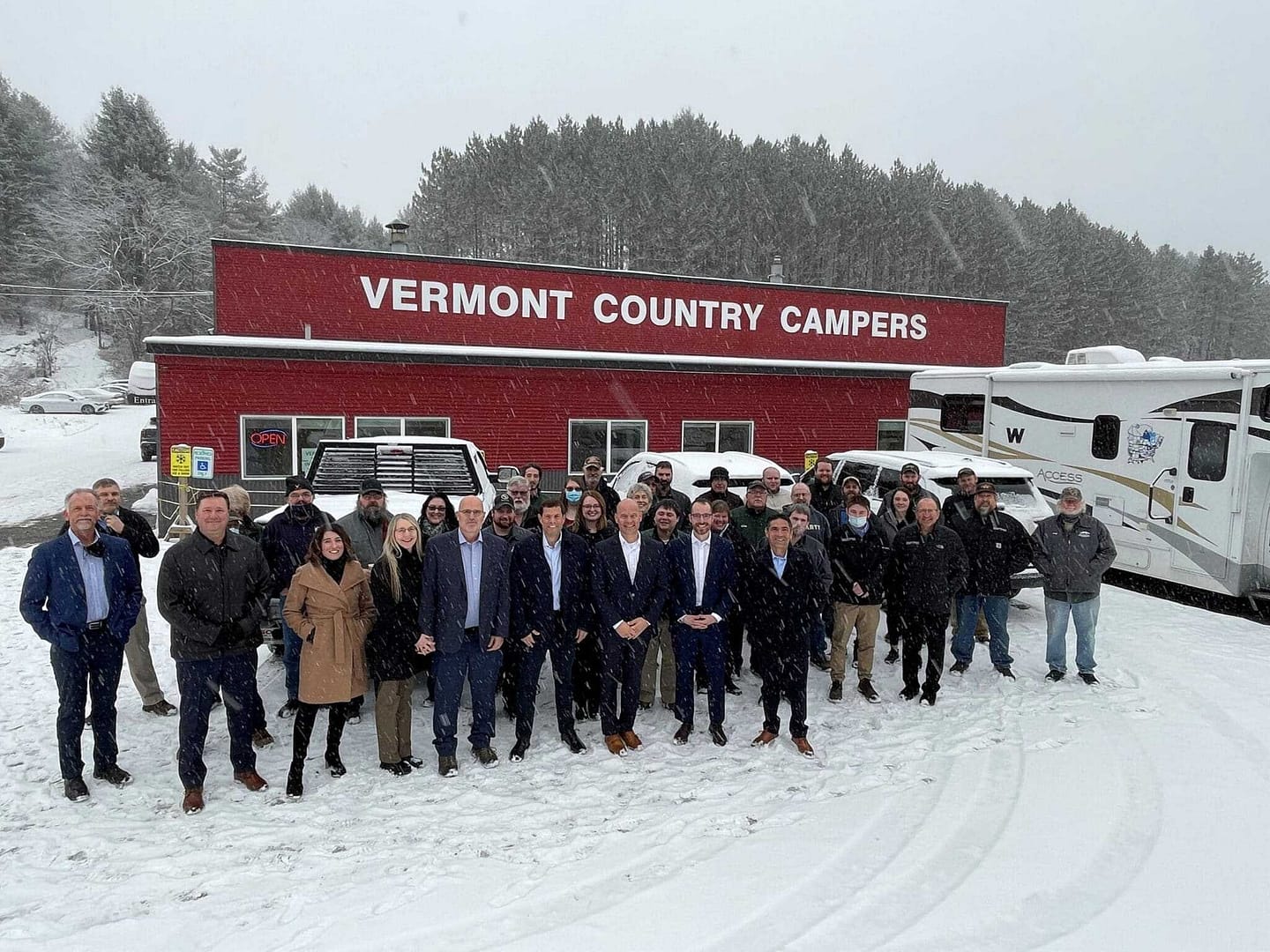 Acquires: A group of people standing in front of an RV.