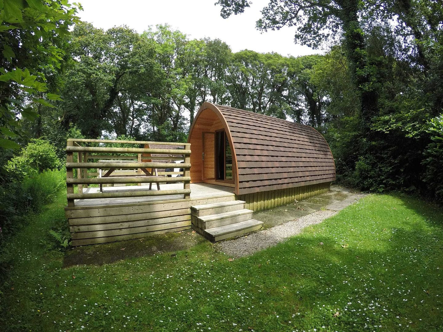 A cozy wooden cabin nestled in the heart of Scotland's picturesque countryside, offering short term accommodation amidst a serene grassy landscape.