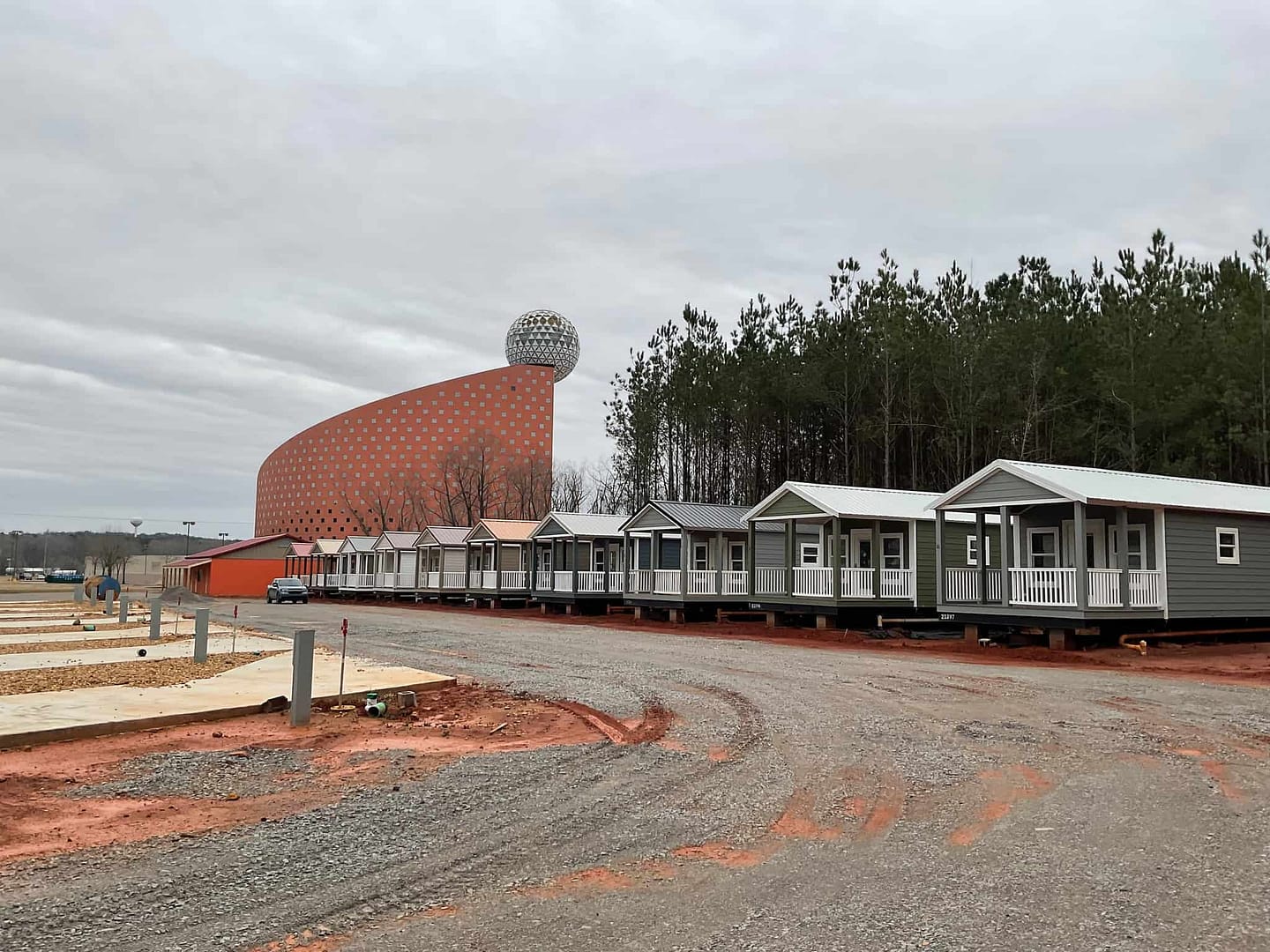 A row of Tiny homes in front of a building.