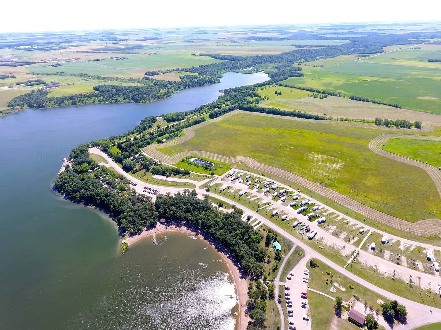 Enjoy a mesmerizing aerial view of Lake Minnewasta, where you can experience the tranquility and natural beauty of this campground nestled by the shimmering lake.