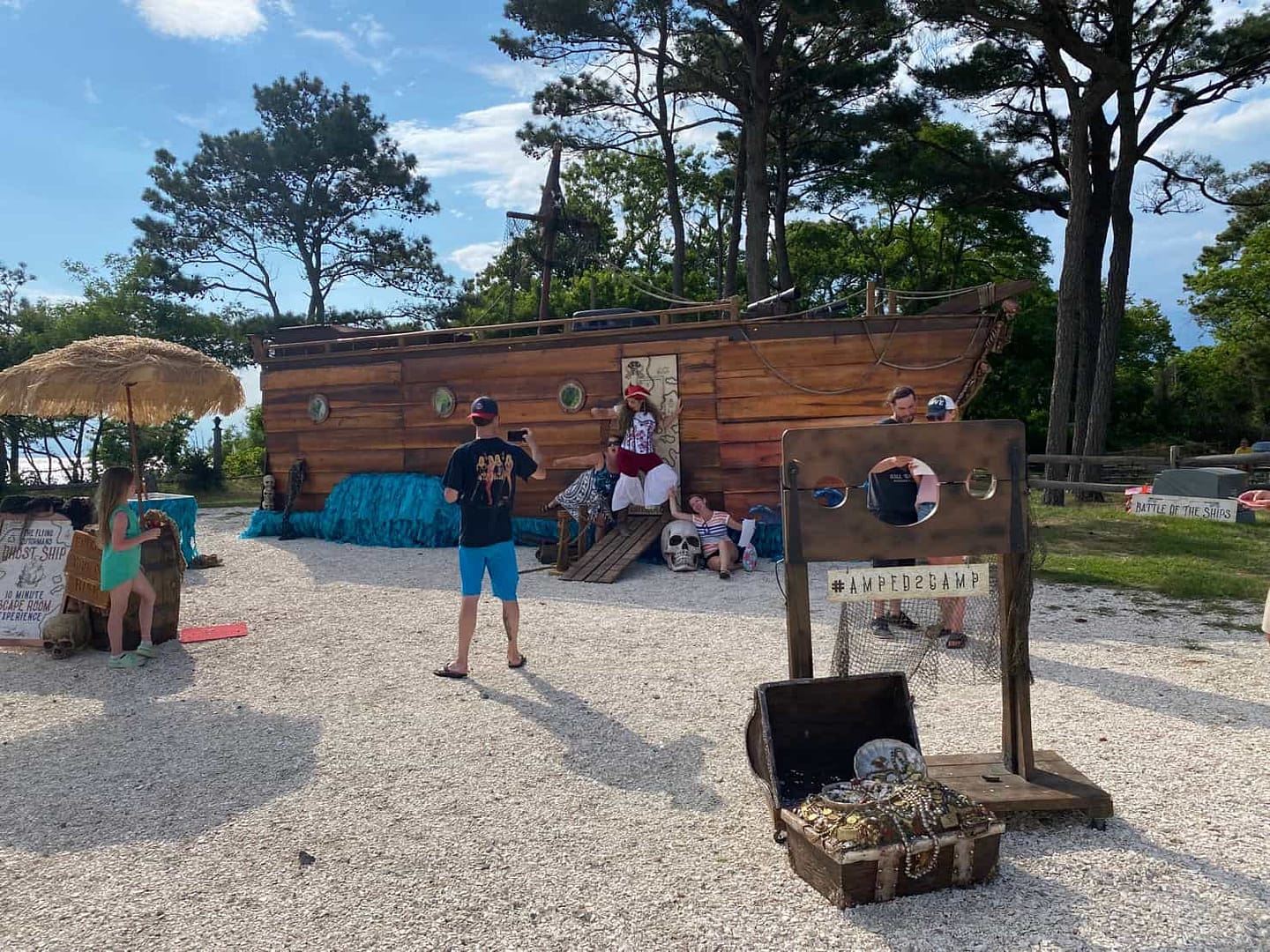 A group of people standing in front of a pirate ship at Chesapeake Bay KOA, excitedly preparing for their upcoming Pirate Ship Escape Room adventure.